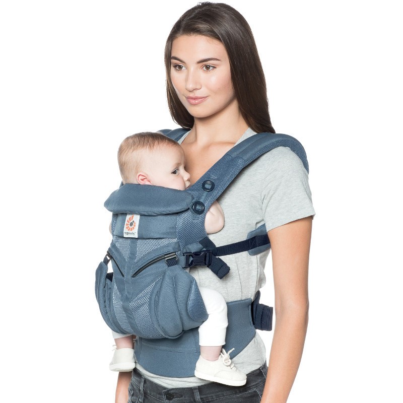 Female model carrying a baby in Ergobaby Omni 360 cool mesh in oxford blue