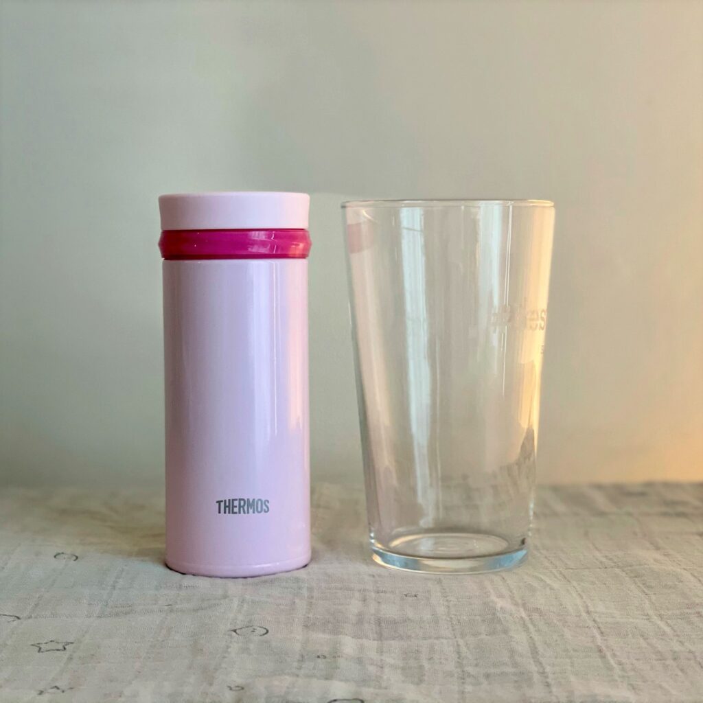 Pink 250ml Thermos and a UK pint glass to compare the size