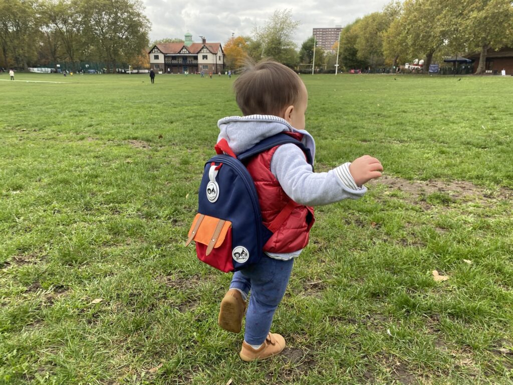 1 year old toddler wearing Zip & Zoe mini backpack in navy colourblock