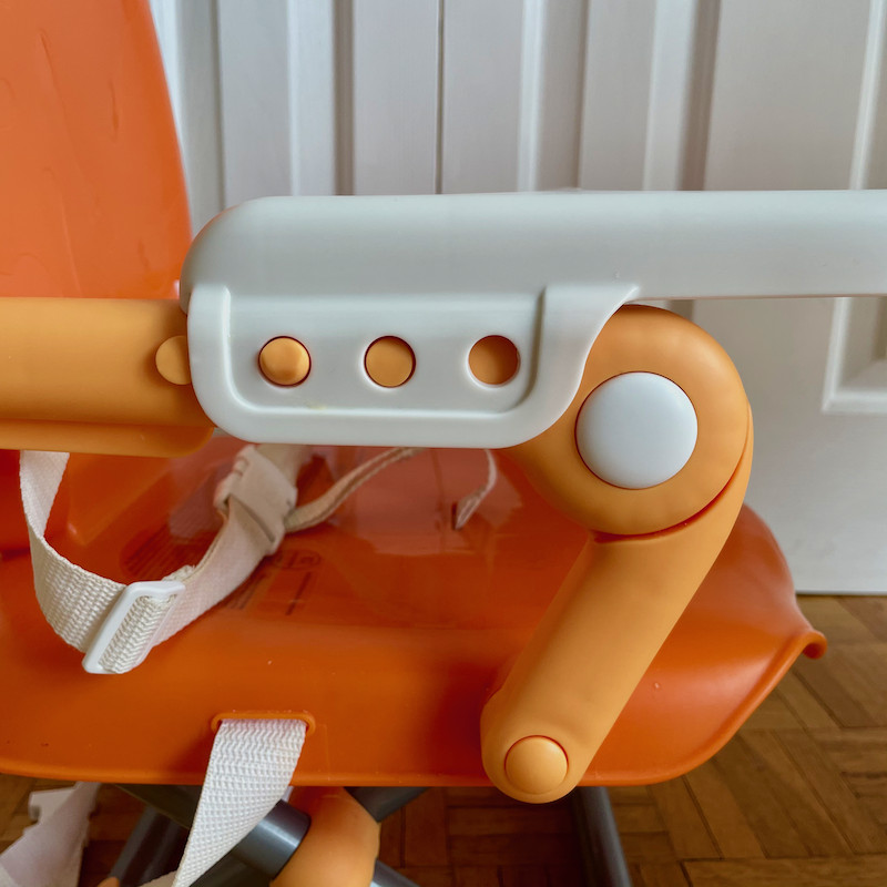 Author's Chicco Pocket Snack Booster Seat in orange close up of side of tray