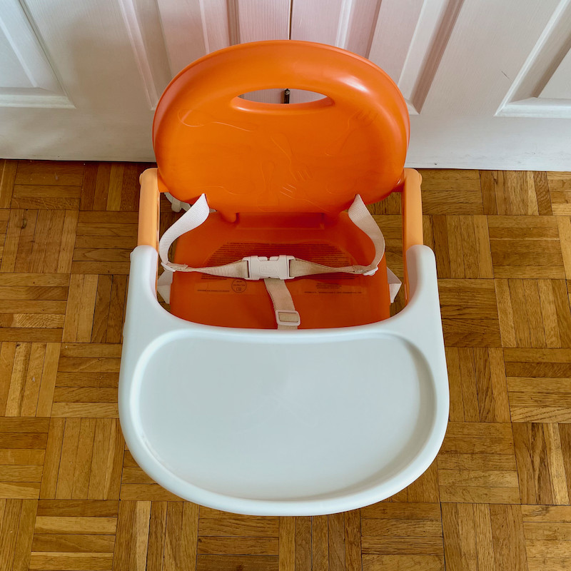 Author's Chicco Pocket Snack Booster Seat in orange with tray from above