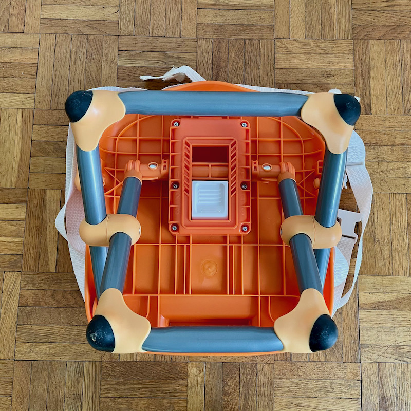 Author's Chicco Pocket Snack Booster Seat in orange underneath showing legs