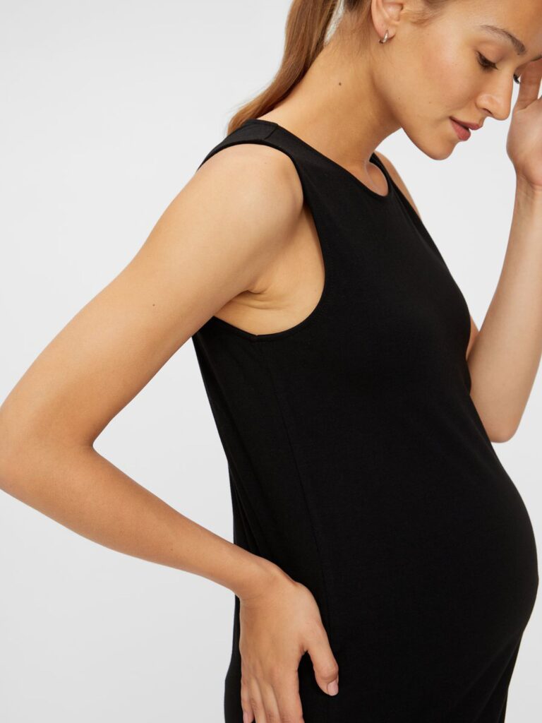 Model wearing Mamalicious sleeveless bodycon maternity dress in black - side view
