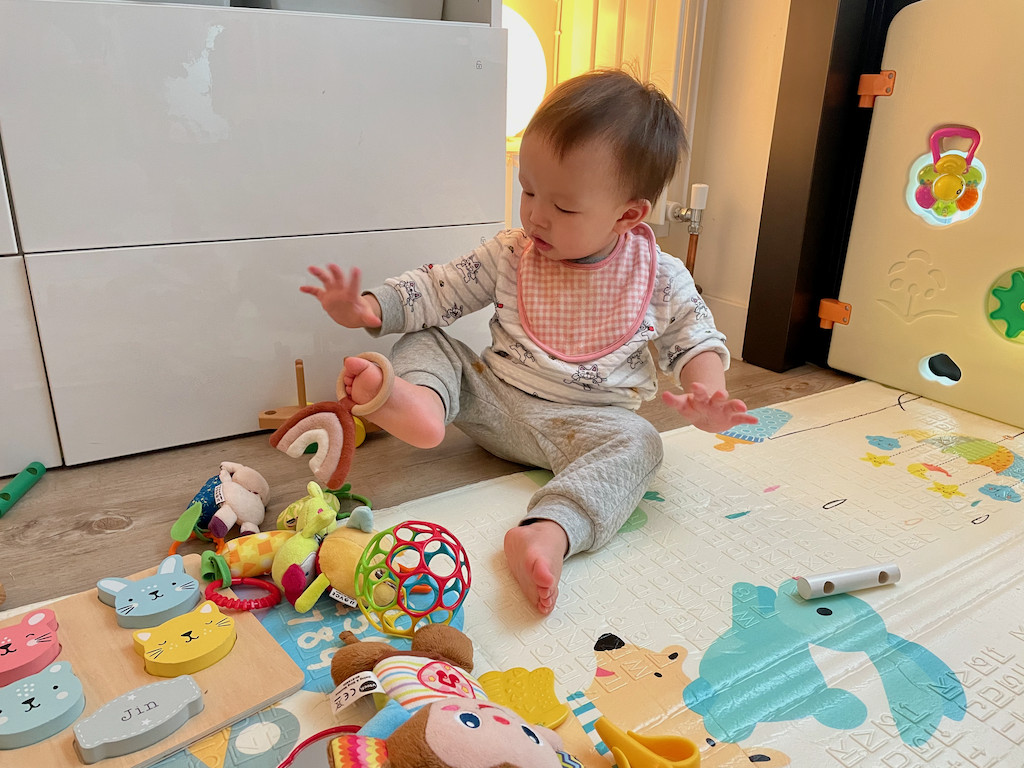 Boy playing with organic rainbow toy on foot