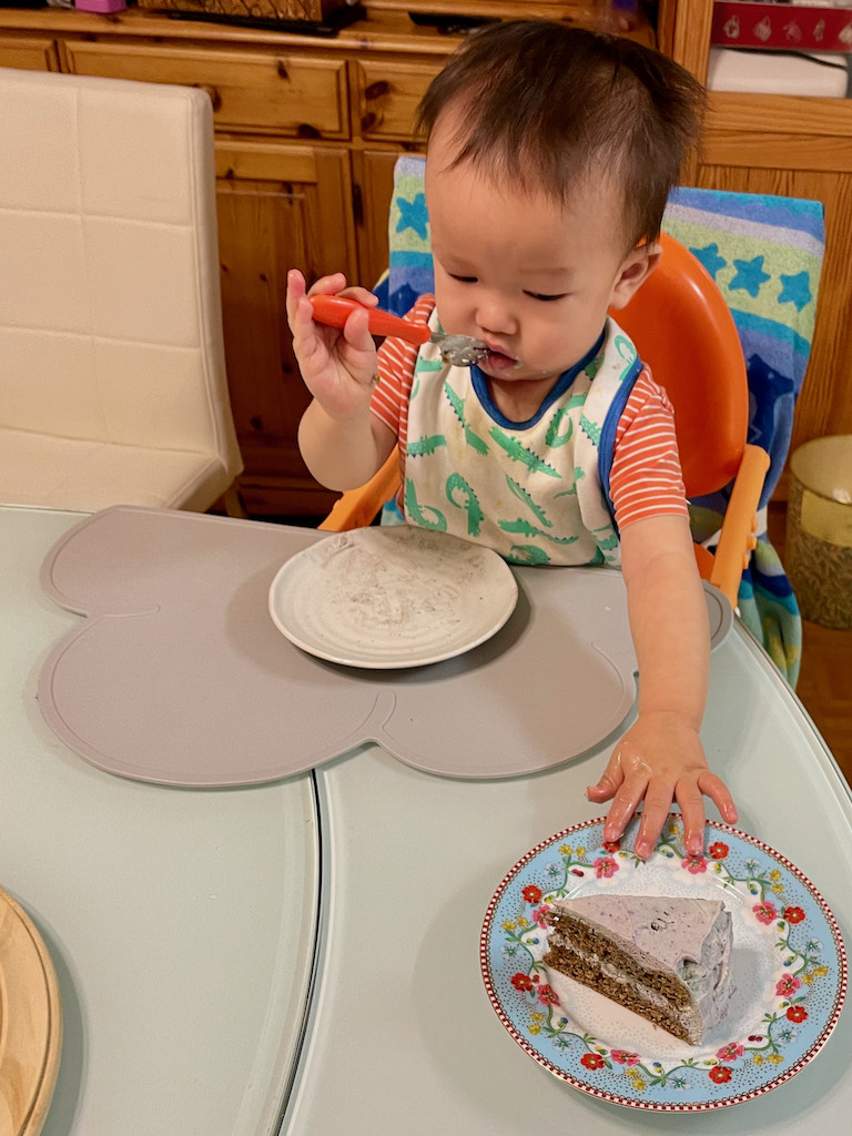 Jin reaching for more smash cake with blueberry whipped cream